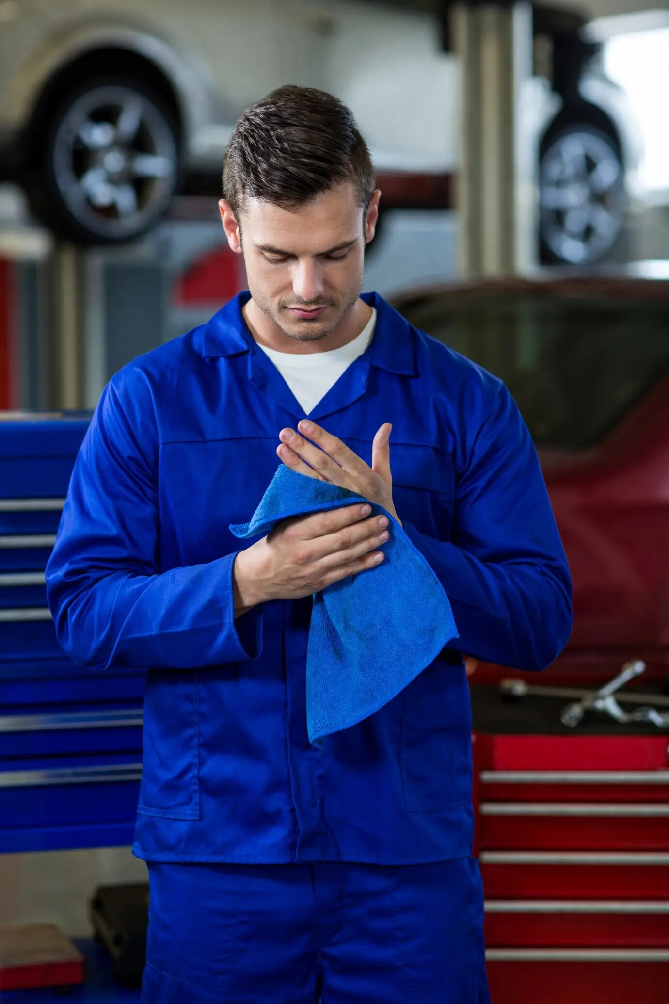 Mechaniker, der sich die Hände mit einem Reinigungstuch abwischt